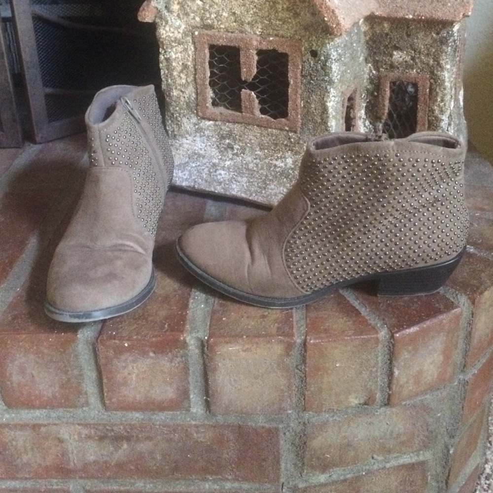 Brown ankle boots with metal grommets.